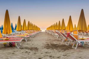 The deserted beach before sunset with closed umbrellas